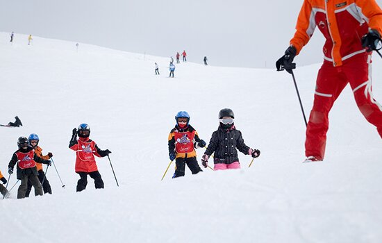 Kinder beim Skikurs mit Skilehrer